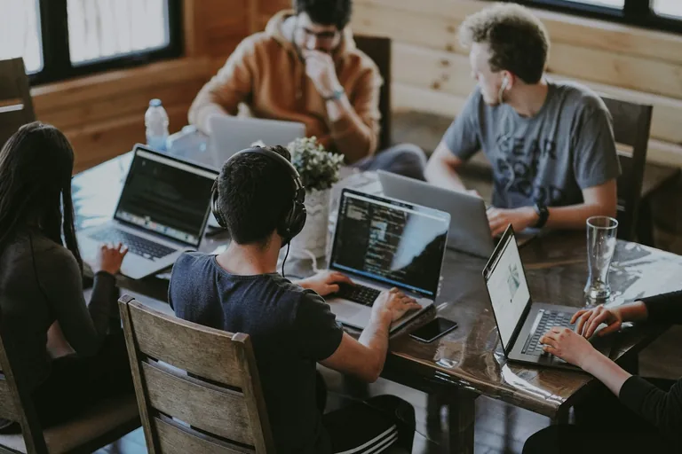 People working together at a table with laptops